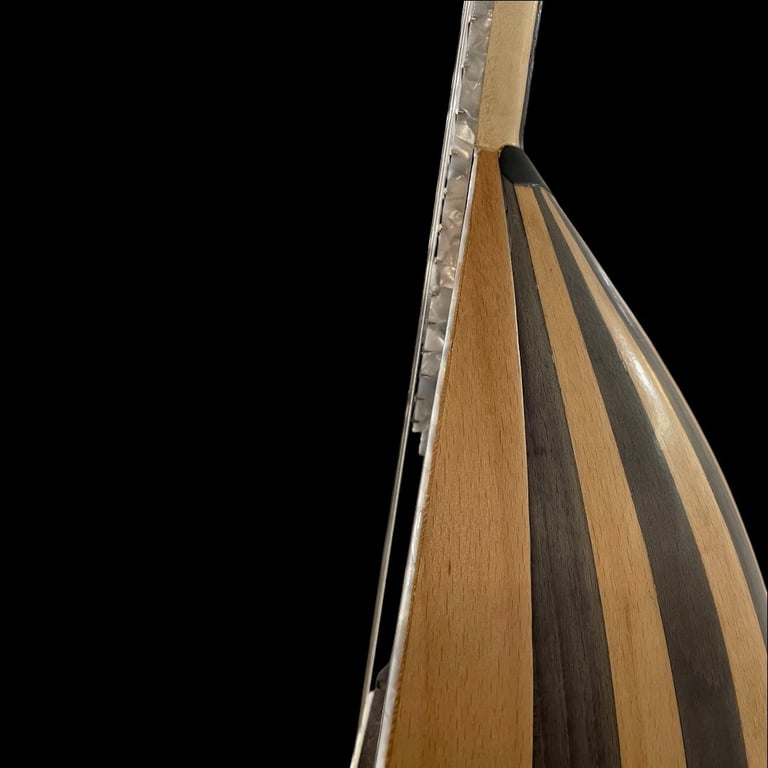 Close-up of acoustic guitar body showing wooden striped pattern and metal strings against black background