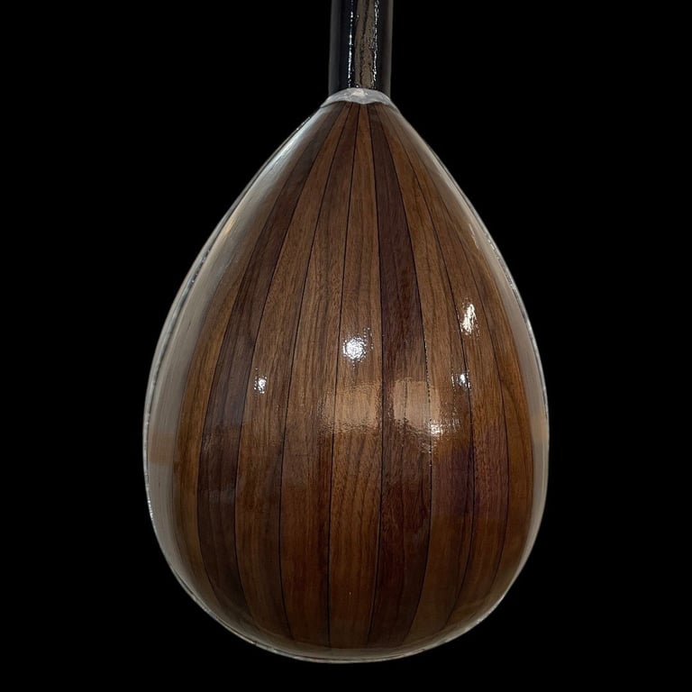 Teardrop-shaped pendant lamp with dark wood veneer finish and translucent glass exterior on black background