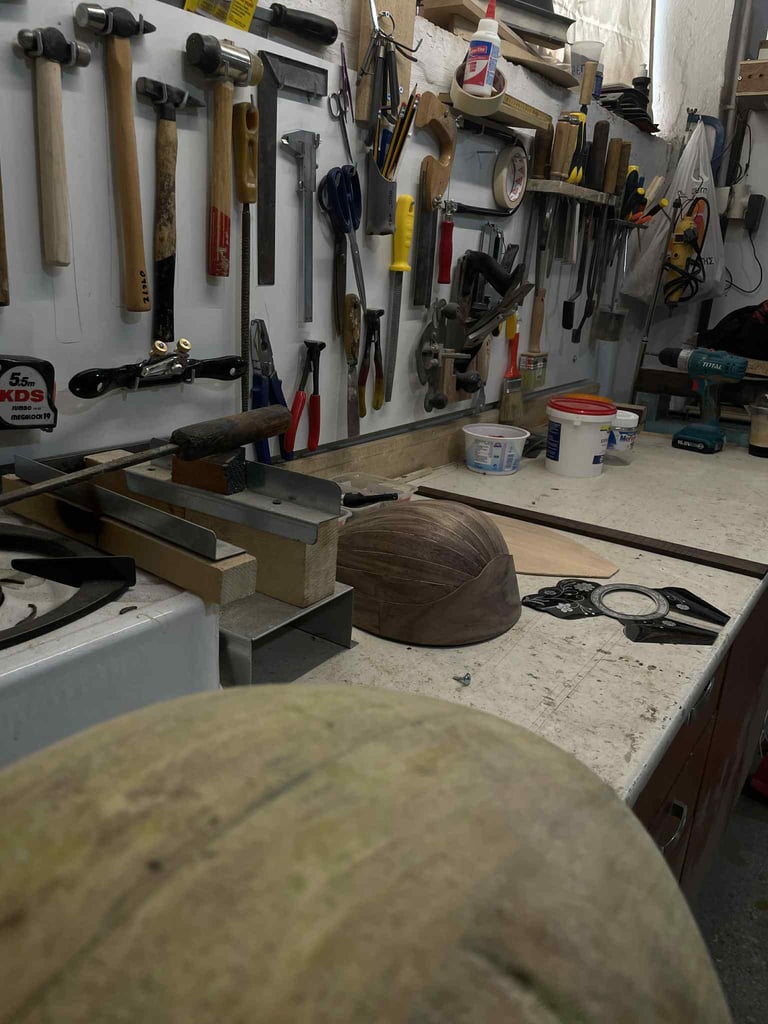 Organized garage workshop with pegboard wall storage displaying various hand tools, hammers, and wrenches above a workbench with clamped wood piece