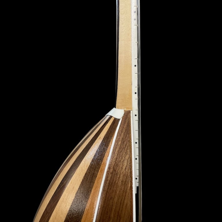 Close-up of wooden guitar headstock showing inlaid wood stripes and tuning peg holes against a black background
