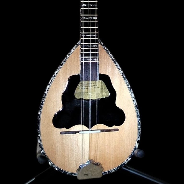 Front view of a natural wood mandolin with teardrop-shaped body, black soundhole, and decorative pearl inlay border on a black background.