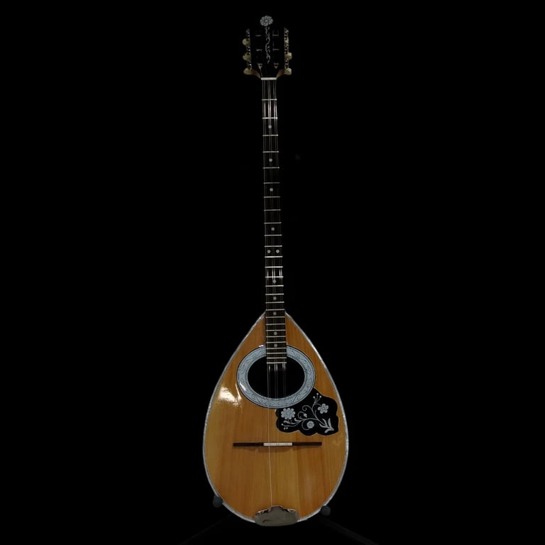 Wooden mandolin with teardrop-shaped body, dark fretboard, and metal pickguard on black background