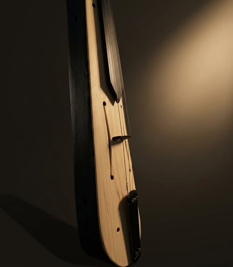 Close-up side view of an acoustic guitar headstock and neck against a dark background with dramatic lighting