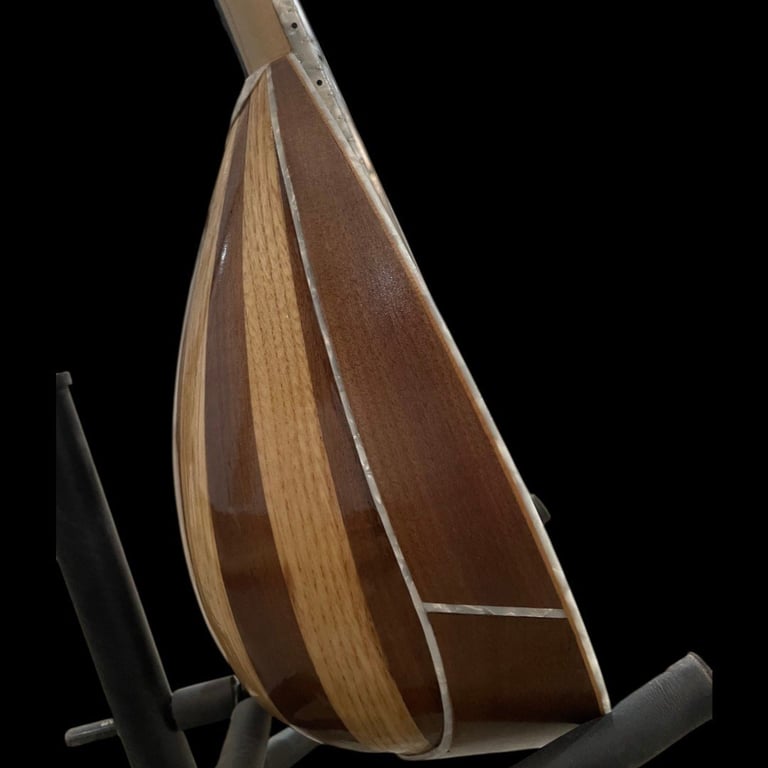 Side view of an acoustic mandolin showing wooden body with light and dark wood grain details against black background