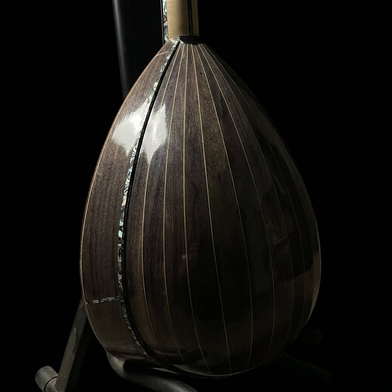 Close-up of a dark punching bag with vertical ribbed panels and a rope attachment against a black background