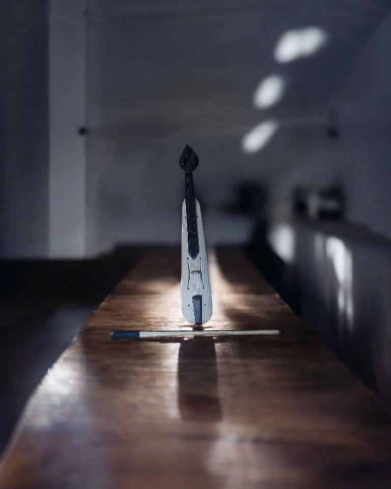 White and black dental model positioned upright on a wooden table indoors with blurred background
