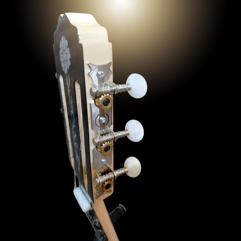 Close-up of guitar headstock with three white tuning pegs on wooden neck against dark background